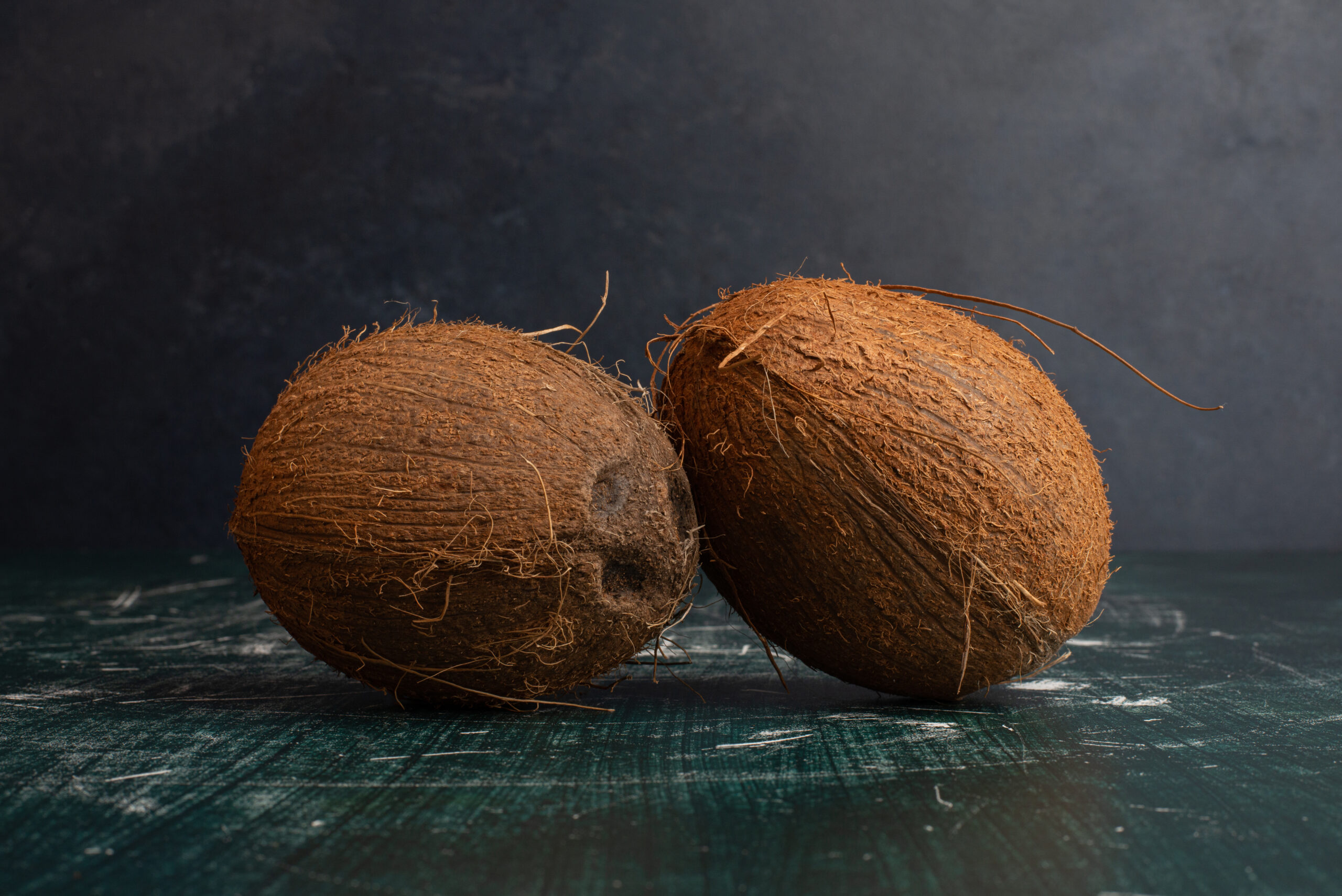 Two whole coconuts on marble table. High quality photo